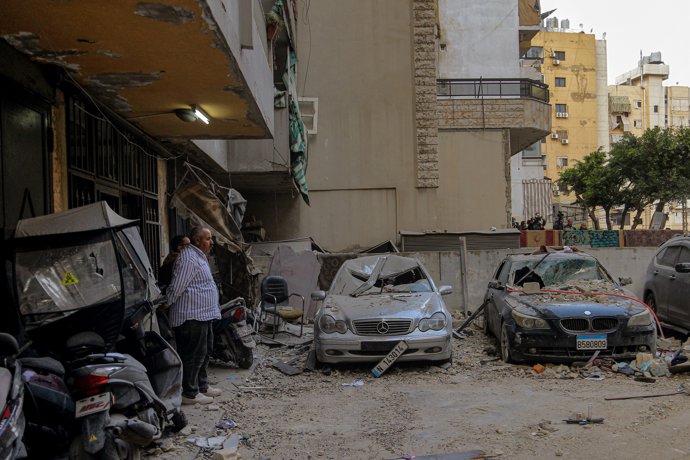 Archivo - 01 April 2025, Lebanon, Beirut: People inspect destroyed cars after an Israeli airstrike hit a building in Beirut's southern suburbs, a Hezbollah stronghold, damaging its upper floors. The attack, which occurred around 3:30 a.m. (0030 GMT) durin