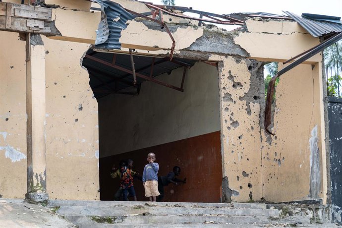 Archivo - GOMA, May 14, 2025  -- This photo taken on May 11, 2025 shows children playing in front of a building damaged during the conflict at the town of Sake, the Democratic Republic of the Congo (DRC). TO GO WITH "Feature: Scars of war remain achingly 