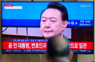 Archivo - April 21, 2025, Seoul, South Korea: A man looks at a 24-hour Yonhap news TV broadcast at Seoul Railway Station showing a news broadcast with South Korea's former president Yoon Suk Yeol attending the second hearing of his insurrection trial at a