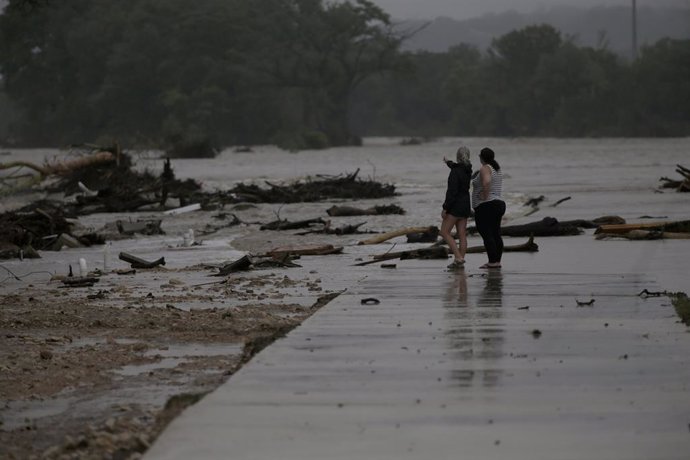 4 de julho de 2025, Kerrville, Texas, EUA: Dois funcionários do HTR RV Park, que não quiseram se identificar, observam a área onde dezenas de trailers foram arrastados pelas águas da enchente do rio Guadalupe em Ingram, Texas, nas primeiras horas da manhã