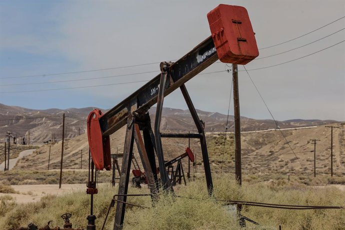 July 4, 2025, Maricopa, Ca, USA: Oil Well in Maricopa, California, and a smoke cloud from the Madre Fire.