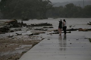 July 4, 2025, Kerrville, Texas, USA: Two employees who wished to remain nameless, from HTR RV Park, look over the area where dozens of trailers were sweep away by rising flood waters on the Guadalupe River in Ingram, TX in early morning hours on July 4, 2