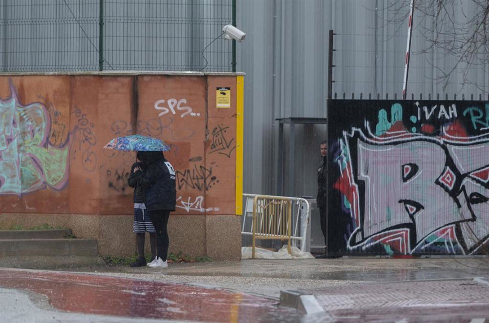 Archivo - Dos migrantes se protegen de la lluvia con un paraguas en las inmediaciones del centro de Emergencia, Acogida y Derivación en el Acuartelamiento 'Primo de Rivera', donde se alojan migrantes procedentes de Canarias, a 19 de enero de 2024, en Al