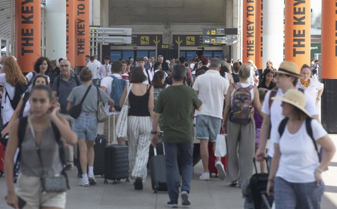 05 July 2025, Spain, Palma: People walk through the hall of Palma de Mallorca Airport. Due to a false fire alarm, dozens of people had to hastily leave a Ryanair plane via the emergency exits at Palma Airport on Saturday night. Photo: Clara Margais/dpa