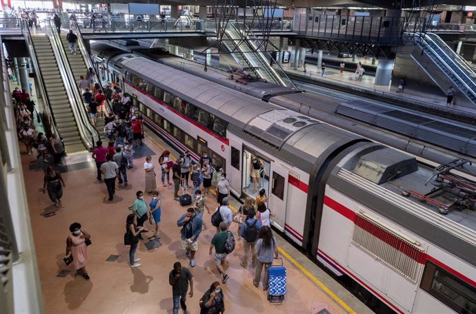 Archivo - Varios viajeros suben al tren en los andenes de cercanías de la estación de tren de Atocha