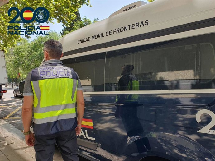Un agente de la Policía Nacional junto a una unidad móvil de fronteras