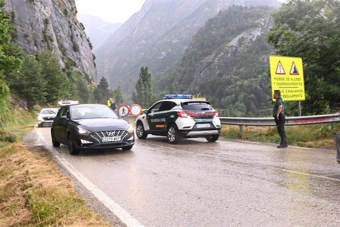 Un turismo pasa junto a un vehículo de la Guardia Civil este pasado viernes en la carretera del Balneario de Panticosa. A-2606 que ha quedado reabierta este domingo. 