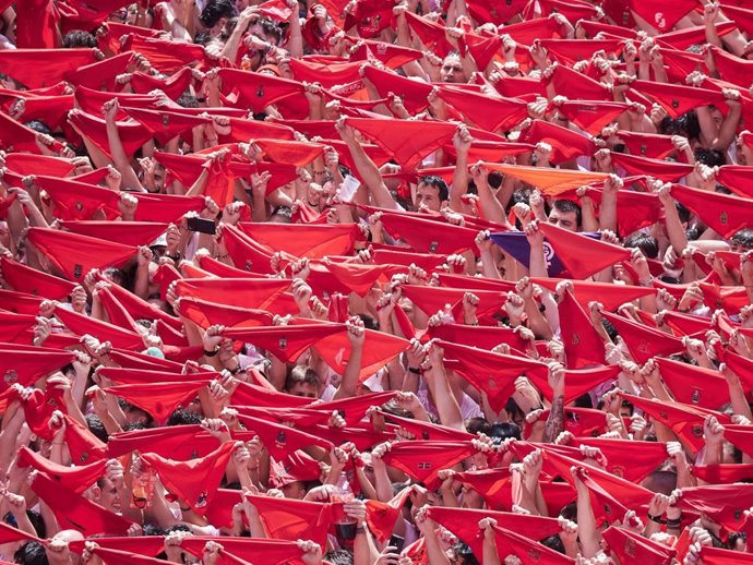 Cientos de personas alzan sus pañuelos rojos durante el chupinazo de inicio de los Sanfermines 2025.