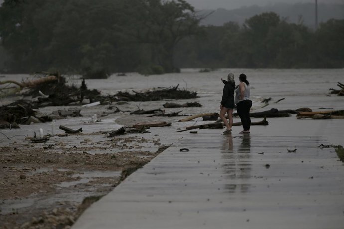 July 4, 2025, Kerrville, Texas, USA: Two employees who wished to remain nameless, from HTR RV Park, look over the area where dozens of trailers were sweep away by rising flood waters on the Guadalupe River in Ingram, TX in early morning hours on July 4, 2