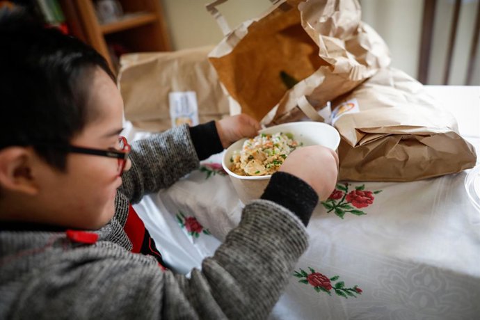 Archivo - Un niño durante la comida en su casa del barrio madrileño de Carabanchel abre la tapa de un plato del menú de la ONG del chef José Andrés, que reparte en Madrid a las familias más necesitadas durante el estado de alarma provocado por el coronavi