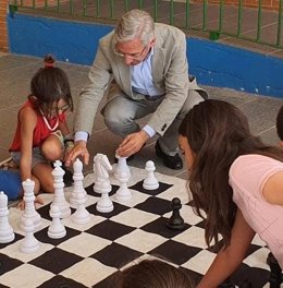 El delegado de Desarrollo Educativo y Formación Profesional y de Universidad, Investigación e Innovación, Miguel Ángel Araúz, jugando al ajedrez con niños. 