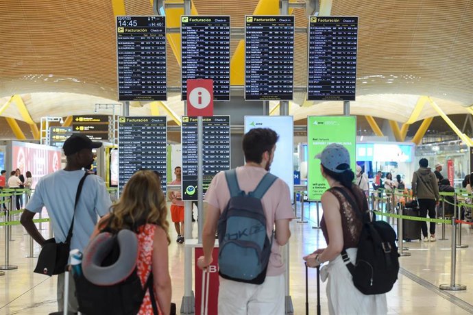 Pasajeros esperan en la entrada de la Terminal 4 de Barajas