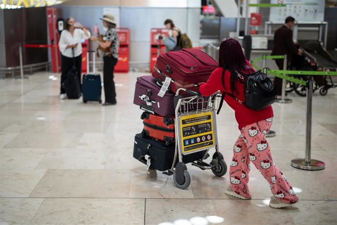 Una mujer con varias maletas en el aeropuerto Adolfo Suárez Madrid-Barajas durante la primera operación salida del verano 2025, a 27 de junio de 2025, en Madrid (España). 