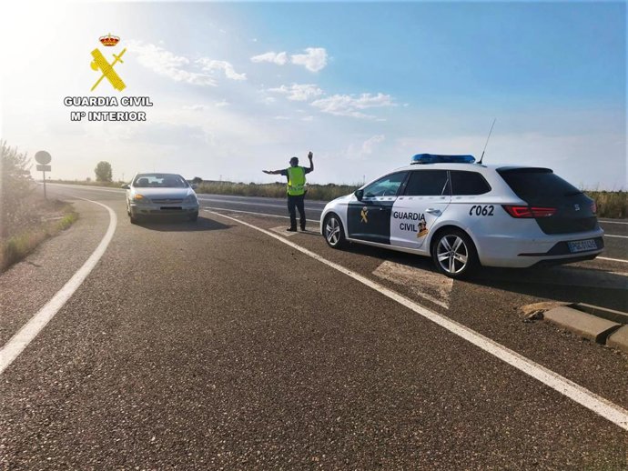 Imagen de un agente de la Guardia Civil dando el alto a un vehículo.