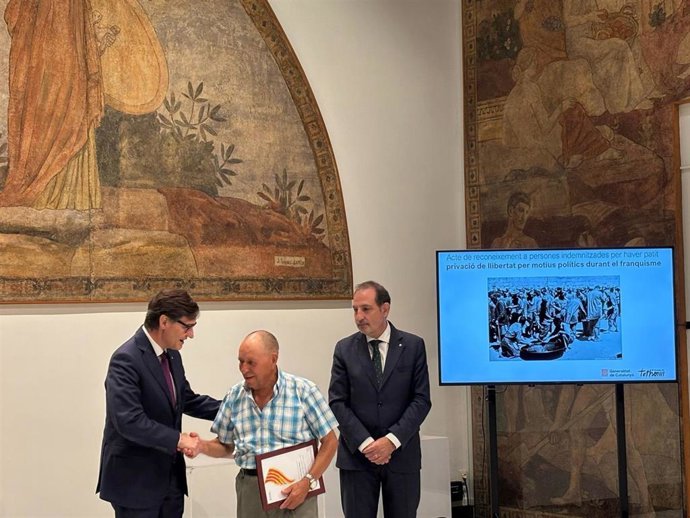 El presidente de la Generalitat de Catalunya, Salvador Illa, entrega un diploma a una de las víctimas del franquismo