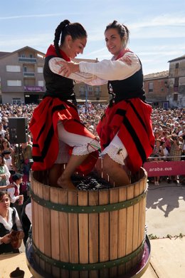 Archivo - Dos mujeres con traje tradicional pisan la uva en una cuba durante la Fiesta de la Vendimia, a 18 de septiembre de 2022, en Lanciego, Álava, País Vasco, (España).
