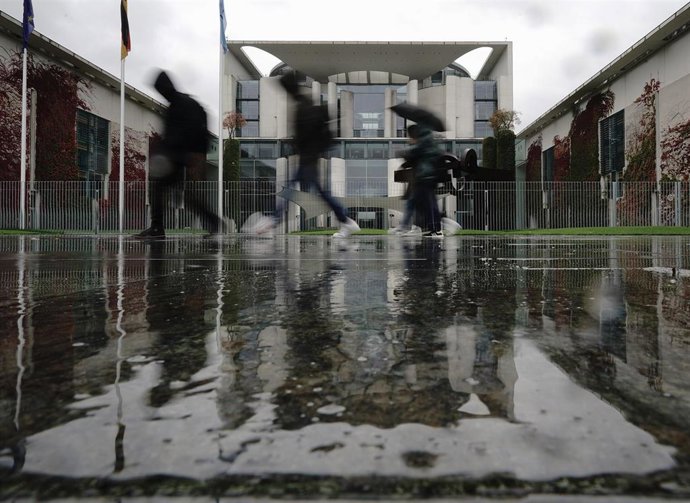 Archivo - Varias personas pasan ante la sede de la Cancillería alemana en Berlín