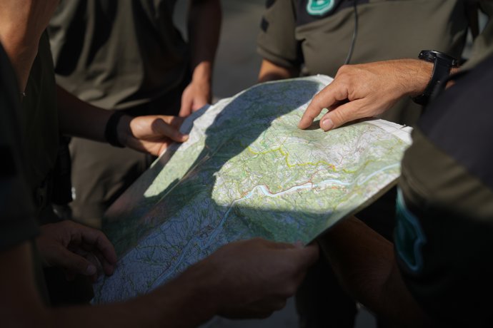 Agentes forestales con un mapa en el puesto de control del Pabellón Ferial de Remolins