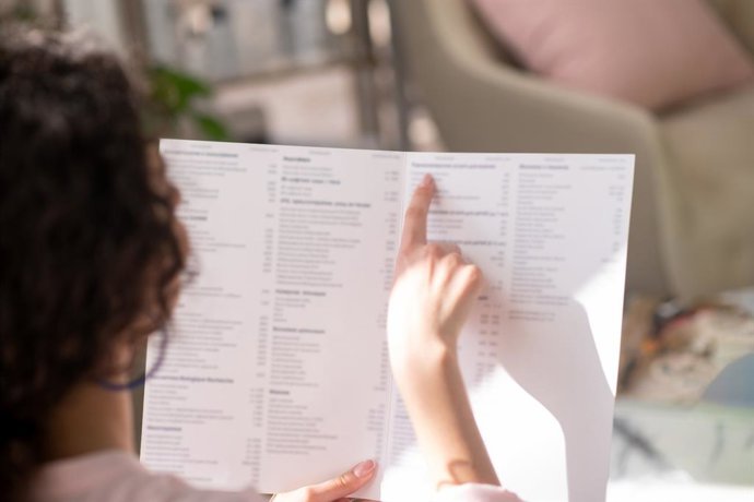 Mujer leyendo carta de un restaurante.