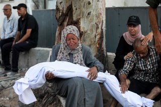 06 July 2025, Palestinian Territories, Gaza: A womman cries as she holds the dead body of one of the Palestinians killed in Israeli airstrikes that targeted civilian homes in Gaza City, Gaza, killing over 20 Palestinians, including women and children. Pho