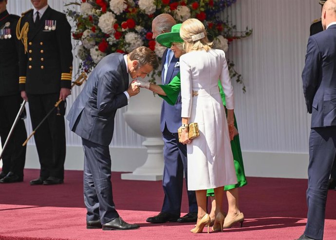 El presidente francés, Emmanuel Macron, en plena reverencia a la reina Camila de Inglaterra.