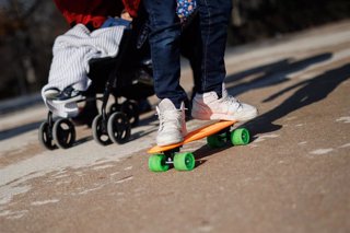 Archivo - Un niño con un patinete pasea por el parque del Retiro.
