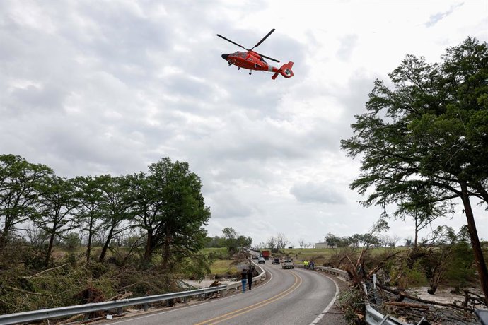 Um helicóptero da Guarda Costeira dos EUA sobrevoa uma ponte ao longo do rio Guadalupe em Center Point, Texas.