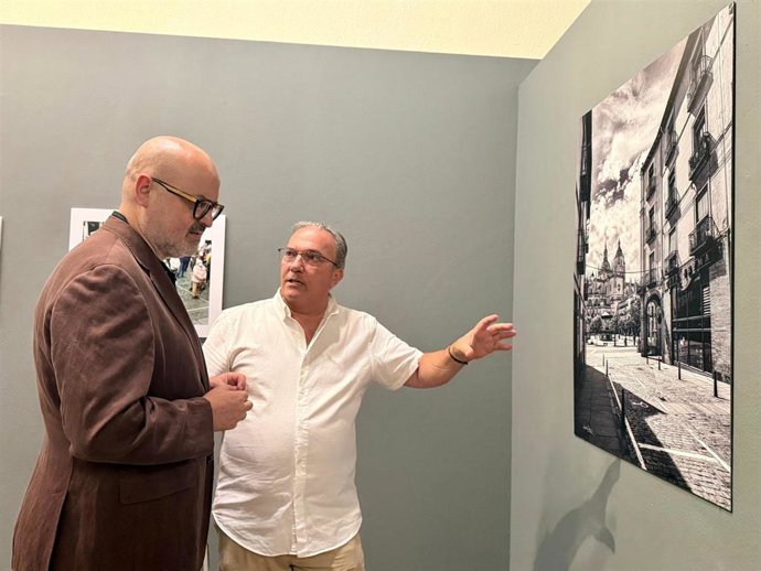 El concejal de Cultura, Juan cArlos Monroy (izda) contempla una fotografía junto a su autor, Juan Luis Misis.