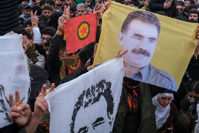 Archivo - FILED - 21 de março de 2025, Turquia, Diyarbakir: Jovens curdos seguram um pôster do líder preso do militante PKK, Abdullah Ocalan. O Partido dos Trabalhadores do Curdistão (PKK), que está sendo proibido, decide se dissolver e encerrar sua luta 