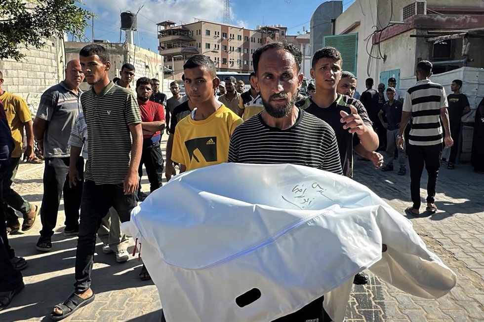 Un palestino transporta el cadáver de un familiar asesinado por Israel.