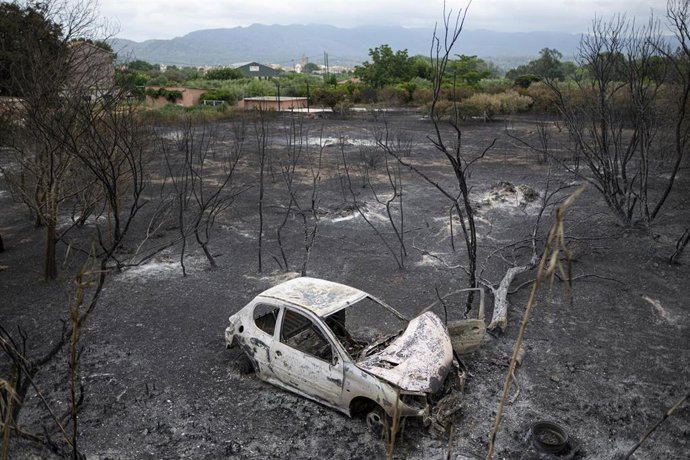 Un coche quemado en una zona afectada por el incendio en Xerta (Tarragona)