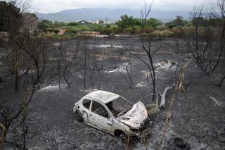 Un cotxe cremat en una zona afectada per l'incendi a Xerta (Tarragona)