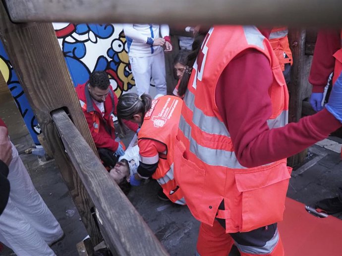 Voluntarios de Cruz Roja atienden a un herido en un encierro.