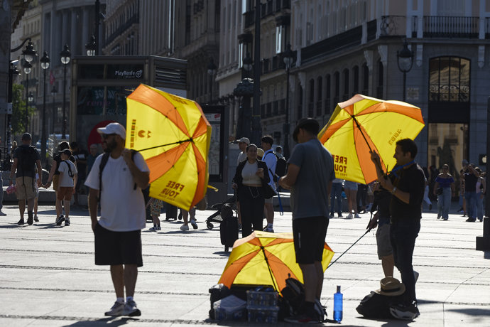 Varias personas pasean por la calle, a 16 de junio de 2025, en Madrid (España). La Agencia Estatal de Meteorología (AEMET) activa el aviso amarillo en Madrid este lunes y martes por temperaturas que superarán los 36 grados en varias zonas de la región. El