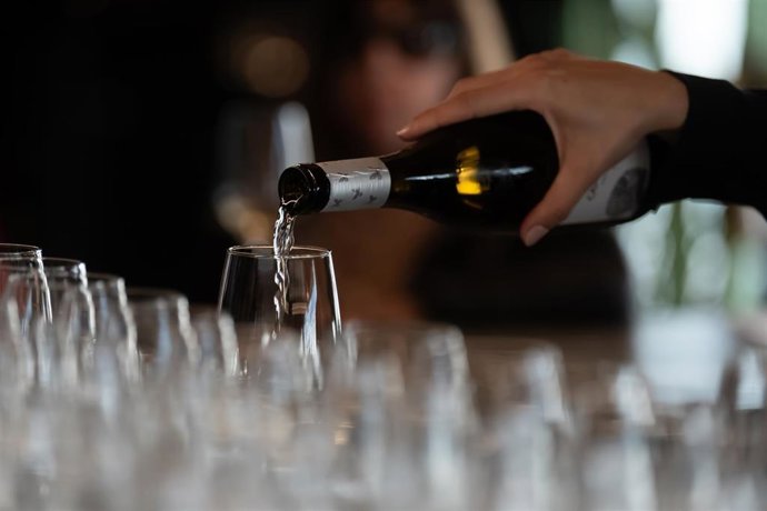 Archivo - Un camarero sirve copas de vino blanco en un bar en Barcelona.