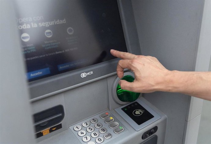 Archivo - Un hombre utiliza un cajero automático, en imagen de archivo