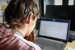 Archivo - Una joven usuaria de audífonos estudiando.