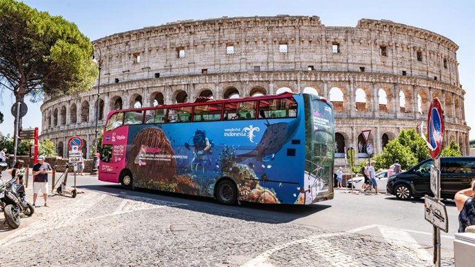 A Rome city tour bus featuring a “Wonderful Indonesia” advertisement passes by the iconic Colosseum, promoting Indonesia's tourism throughout July 2025
