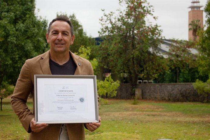 Antonio Fernández-Martínez, vicerrector de Campus Saludable y Deporte, muestra el certificado internacional 'Healthy Campus' otorgado a la UPO por FISU.
