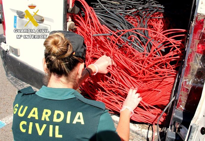 Una agente junto a la furgoneta en la que se intervinieron 400 kilos de cableado de cobre