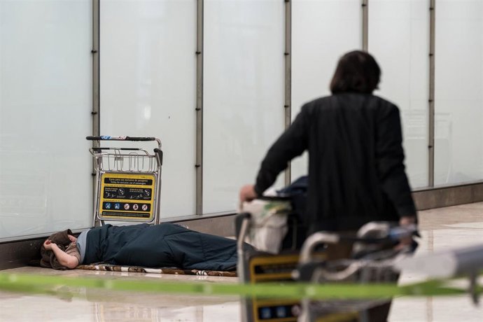 Archivo - Una persona sin hogar en la Terminal 4 del Aeropuerto Adolfo Suárez Madrid-Barajas