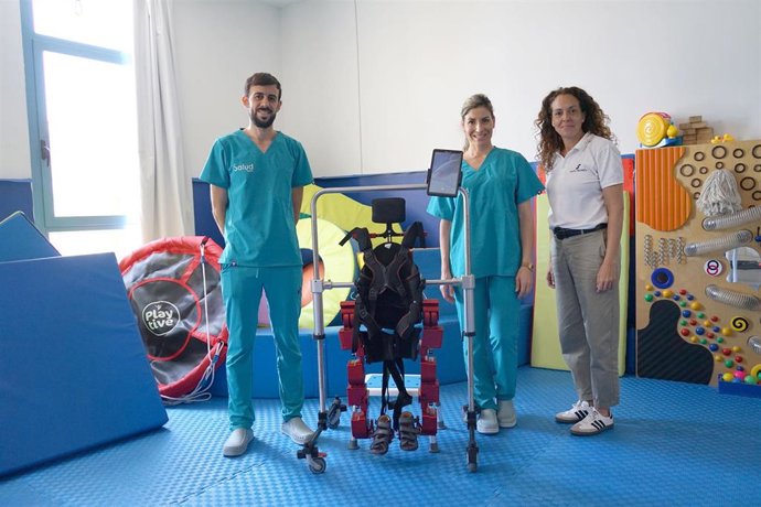 Profesionales junto al exoesqueleto pediátrico.