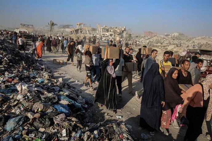 June 16, 2025, Gaza City, Gaza Strip, Palestinian Territory: Palestinians carry food parcel, distributed by 'Gaza Humanitarian Relief Foundation' as people struggle with hunger during ongoing Israeli attacks in Gaza City on June 16, 2025. Palestinians liv