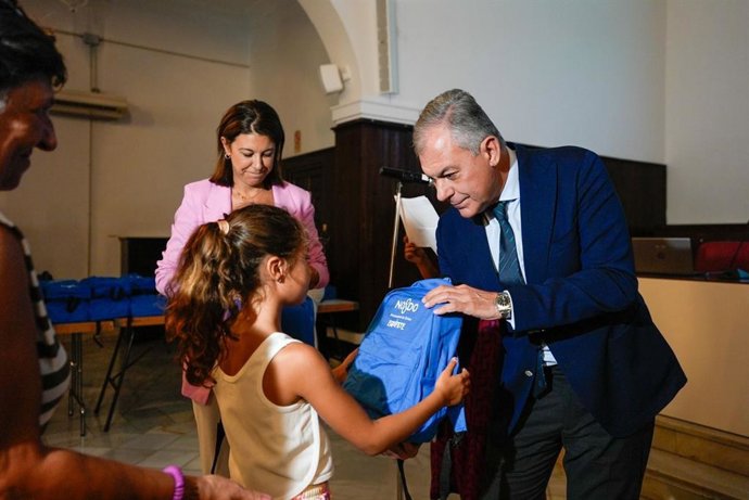 El alcalde de Sevilla, José Luis Sanz, entrega mochilas a niños en Sevilla.