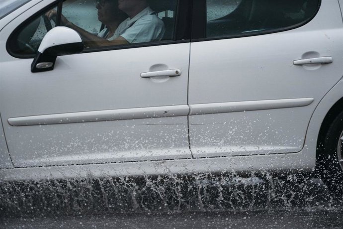 Archivo - Un coche circula bajo la lluvia en Castelló. Imagen de archivo.