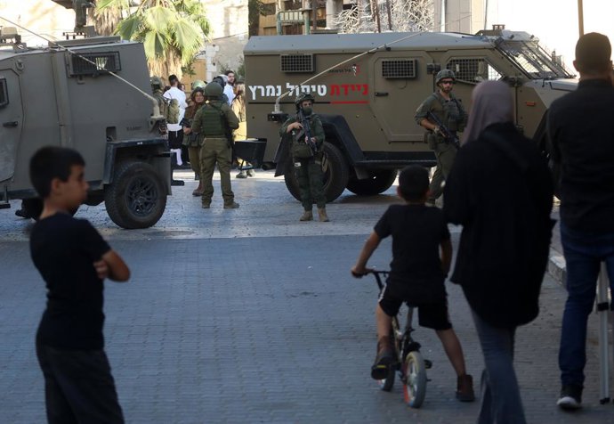 July 12, 2025, Hebron, West Bank, Palestinian Territory: Israeli security forces stand guard as Israeli settlers tour in the Palestinian side of the old city and market of Hebron in the occupied West Bank on July 12, 2025