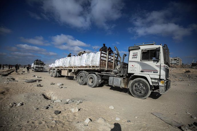 June 25, 2025, Gaza City, Gaza Strip, Palestinian Territory: Palestinians from clans hold melee weapons to secure an aid truck in Beit Lahia, in the northern Gaza Strip, June 25, 2025