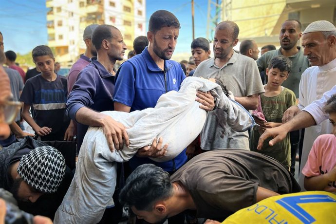 13 de julho de 2025, Nusairat, Faixa de Gaza, Território Palestino: Palestinos choram junto aos corpos de parentes que foram mortos em ataques israelenses contra uma estação de abastecimento de água, no hospital Al-Awda, no campo de refugiados de Nusairat
