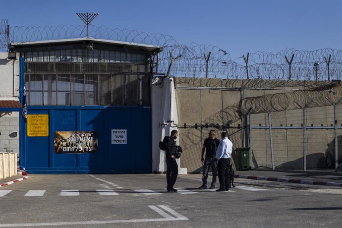 Archivo - Arquivo - 24 de novembro de 2023, Israel, Ramallah/Beitunia: Agentes de segurança israelenses vigiam a entrada da prisão de Ofer, enquanto prisioneiros palestinos chegam de outra prisão israelense, como parte de um acordo entre Israel e o grupo 