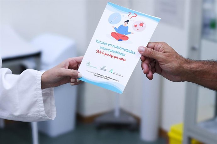 Un profesional sanitario entreg un díptico sobre enfermedades inmunomediadas a un paciente o familiar.